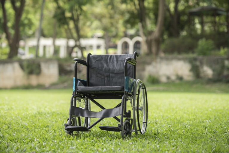 Fauteuil roulant vide dans un parc illustrant le 100% Santé
