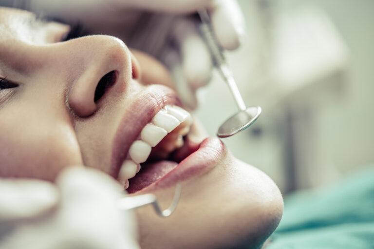 Dentiste traitant un patient illustrant les soins dentaires pris en charge par le dispositif 100 % Santé